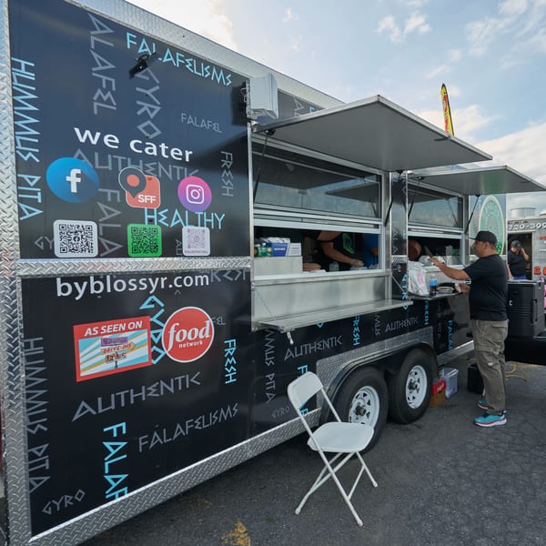 A Byblos Mediterranean Cafe food truck with a customer ordering from the window.