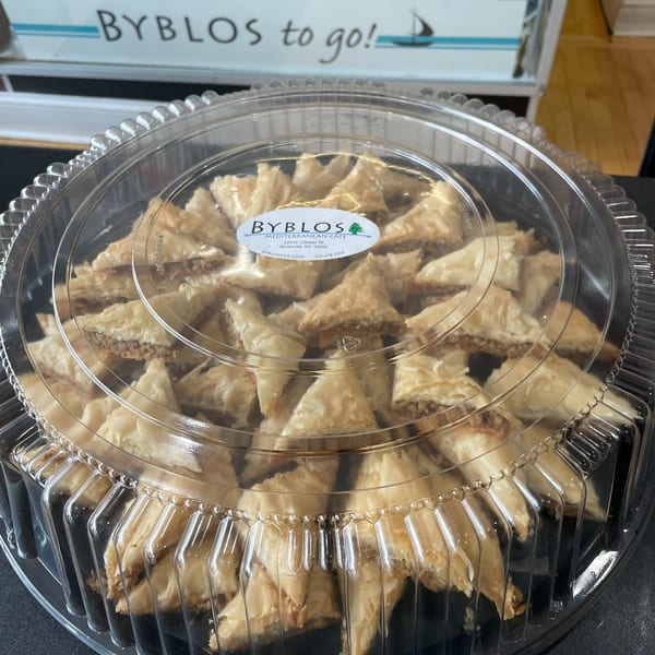 Byblos Mediterranean Cafe baklava pastries in a clear plastic container, ready for takeout.
